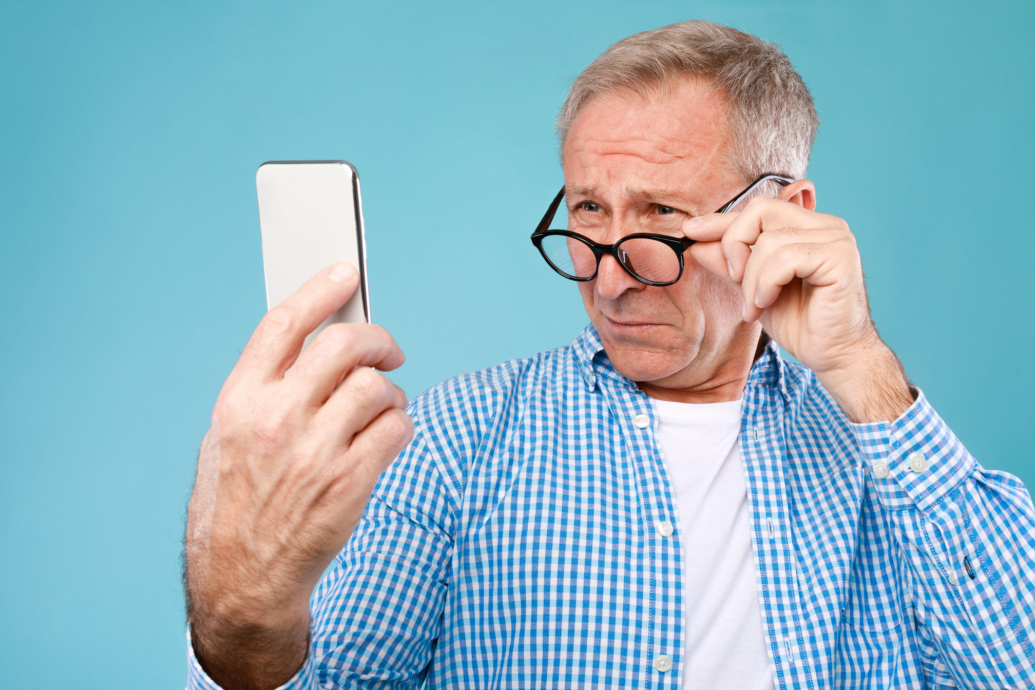 Mature Man Squinting Using Mobile Phone, Looking at Screen